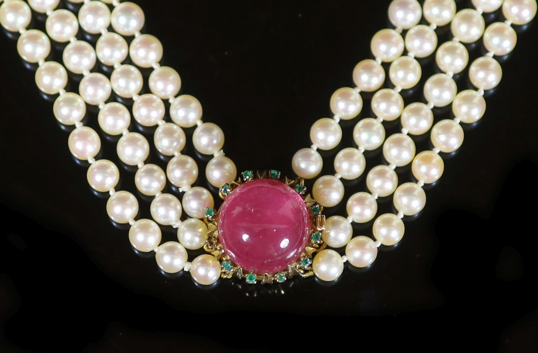 A four-strand graduated cultured pearl choker with circular cabochon pink tourmaline and emerald yellow metal clasp,